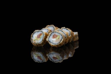 Siyah üzerine izole edilmiş, yakın plan bir suşi rulosu. yansıma