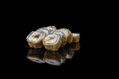 Siyah üzerine izole edilmiş, yakın plan bir suşi rulosu. yansıma