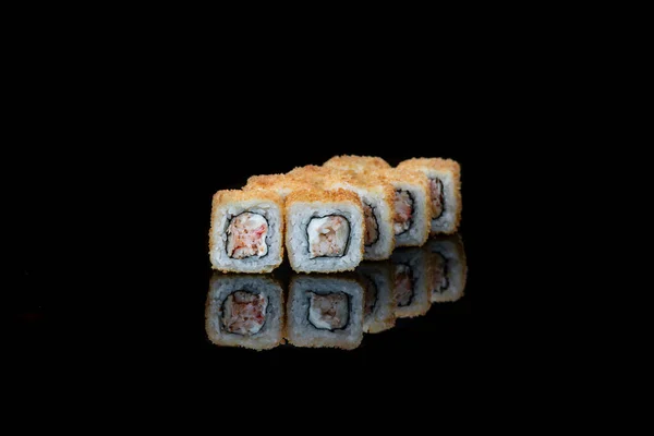 En närbild av mat stekt sushi rullar isolerad på svart. reflektion — Stockfoto