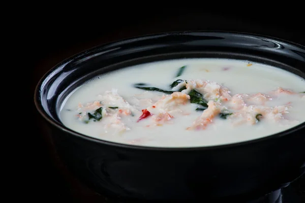 Soup Japonés con pollo, huevo, mushrooms Simeji y Eggplant En un fondo oscuro en un plato negro. cerrar —  Fotos de Stock