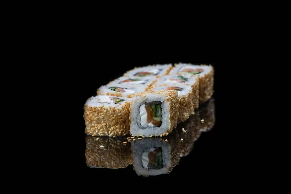 Sushi tekercs egy fekete háttér elmélkedés. Japán kaja. Közelkép. — Stock Fotó