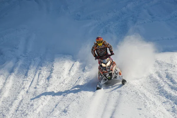 Atleta en una moto de nieve moviéndose en las montañas — Foto de Stock