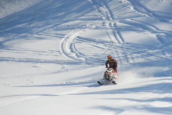 Αθλητής σε ένα snowmobile κινείται στα βουνά — Φωτογραφία Αρχείου
