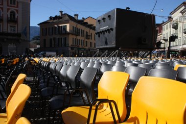 Açık hava sinemasında boş koltuklar ve Locarno Film Festivali renkleriyle Piazza Grande 'de büyük projektörler.