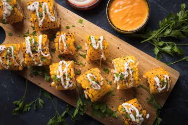 Sağlıklı parti yemeği alternatifi olarak ızgara ve baharatlı mısır dilimleri.