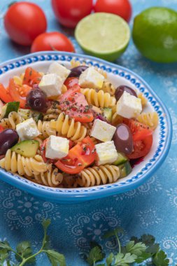 Bir kase peynirli salata, fusili makarna ve taze sebze.