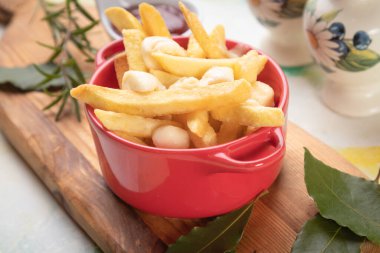 Kanada poutine, kızarmış patates cipsi peynir ve soslu veya soslu.