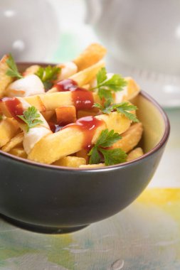 Kanada poutine, kızarmış patates cipsi peynir ve soslu veya soslu.