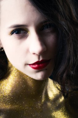 Altın parıltılı güzel bir kızın stüdyo portresi