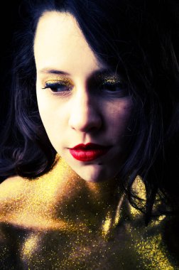 Altın parıltılı güzel bir kızın stüdyo portresi