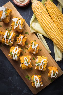 Sağlıklı parti yemeği alternatifi olarak ızgara ve baharatlı mısır dilimleri.
