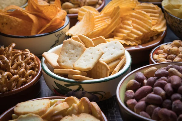 Salty snacks served as party food in ceramic bowls