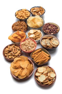 Simitler, patates cipsleri, krakerler ve beyaz arka planda izole edilmiş diğer tuzlu atıştırmalıklar.