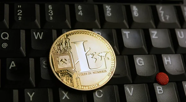 Moneda de oro Litecoin LTC sobre un teclado portátil negro — Foto de Stock