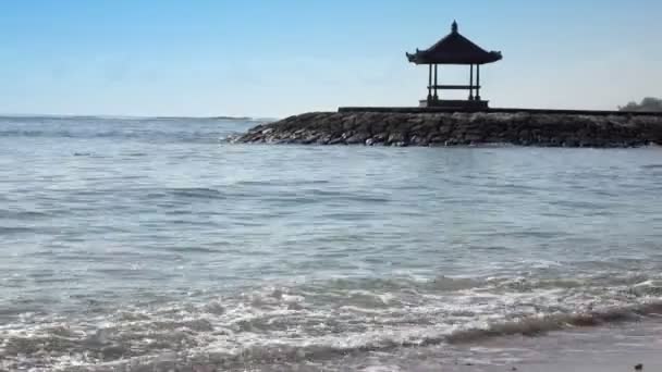 Traditionelle nationale Laube vor dem Hintergrund des blauen Himmels am Ufer des tropischen Strandes bei sonnigem Wetter. bali. Indonesien — Stockvideo