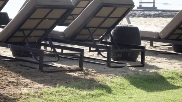 Vågor av det varma havet kör på sandstranden i semesterorten tropiska med parasoll och schäslonger — Stockvideo