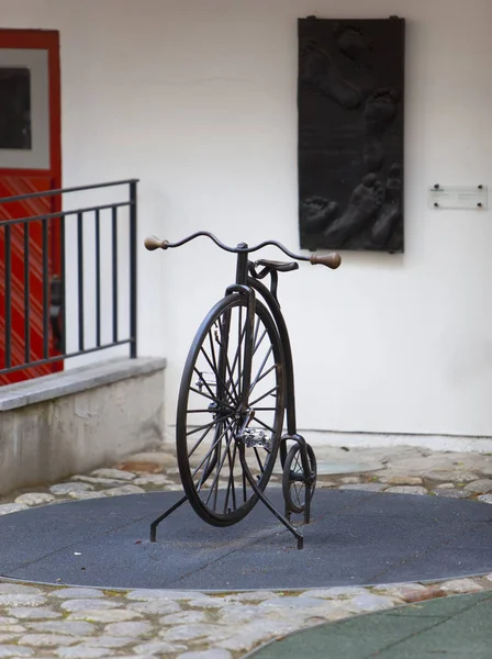在老城塔林的院子里 一辆大轮子和一个小轮子的旧自行车 — 图库照片