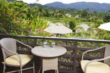 Tablo gözlüklerle pirinç bakan açık bir balkon teras ve dağ