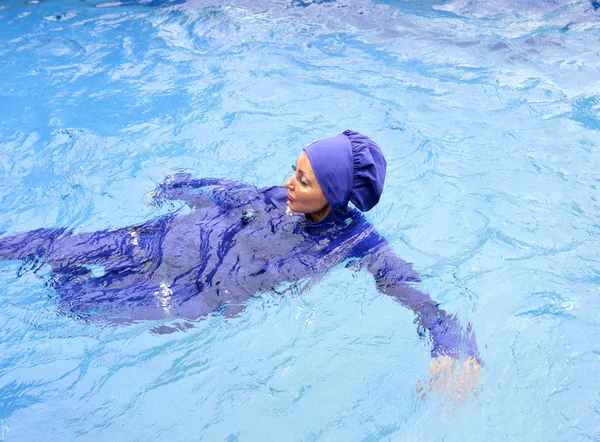 イスラム教徒水着ムスリムの魅力的な女性がプールで泳ぐ — ストック写真