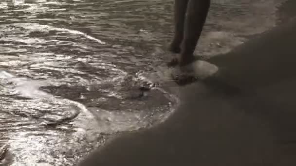 Primer plano piernas femeninas ir en una franja de un mar de surf en la playa tropical de arena temprano en la mañana — Vídeo de stock