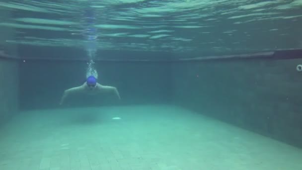 View from water on the young sports man floating under water in the pool — Stock Video