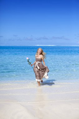 Bir gül bir plajda denizin kenarında güzel kadınla