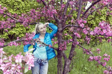 genç çekici kadın ayakta Kızıl çiçek açması yanında elma ağacı