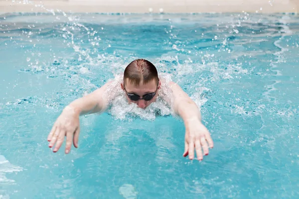 若い男はスポーツスタイルを泳ぐ — ストック写真