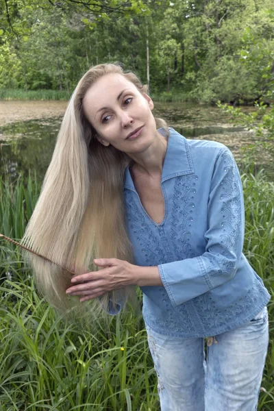 Mooie Vrouw Kammen Lange Haren Zomerdag Rivier Bank — Stockfoto