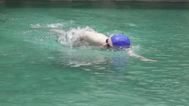年轻的体育男子在游泳池里漂浮在相机上的乳房中风 慢动作 — 图库视频影像