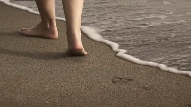 女性の足を閉じるが早朝に熱帯の砂浜で海サーフのストリップに行く — ストック動画