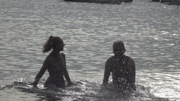 年轻的男人和女人的人 站在海和溅起的水手 慢动作的剪影 — 图库视频影像
