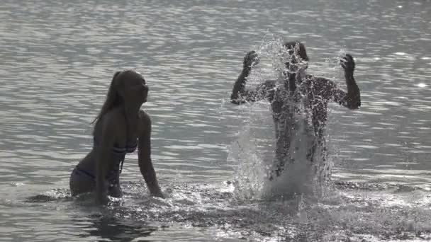 海と水しぶき水の手 スローモーションで立つ男と女の若い人々 のシルエット — ストック動画