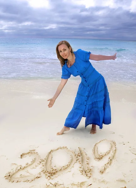 Mulher Vestido Azul Longo Praia Areia Mostra Uma Inscrição 2019 — Fotografia de Stock