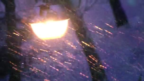Новый год. вид уличного фонаря во время снегопада через стекло, в котором отражается украшенная новая подходящая елка — стоковое видео