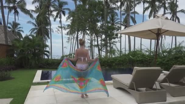 镜头移动为年轻的苗条的女人比基尼去热带度假胜地巴厘岛印度尼西亚的游泳池 — 图库视频影像
