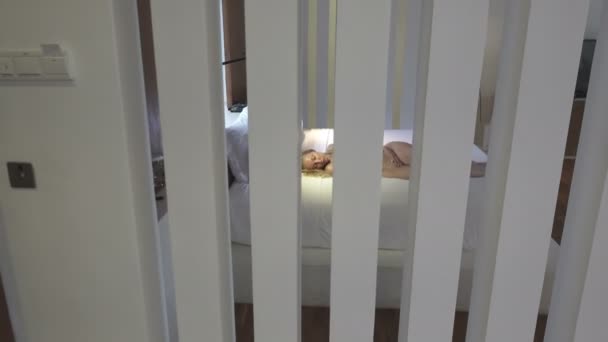 镜头在卧室里移动 关于睡在床上的年轻苗条的女人 — 图库视频影像