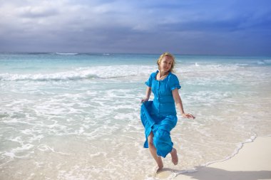 Uzun Mavi elbiseli kadın deniz kıyısında Cayo Largo Adası, Cub gider