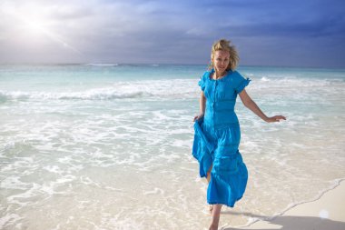 Uzun Mavi elbiseli kadın deniz kıyısında Cayo Largo Adası, Cub gider