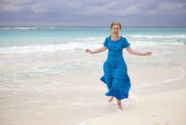 一名身穿蓝色长裙的女子在古巴开波拉戈岛的海岸 — 图库照片