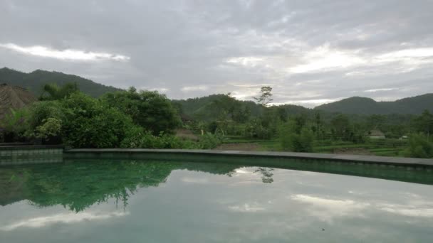 Uitzicht vanaf het zwembad op de rijstvelden van Berg en huis van boeren. Bali, Indonesië — Stockvideo