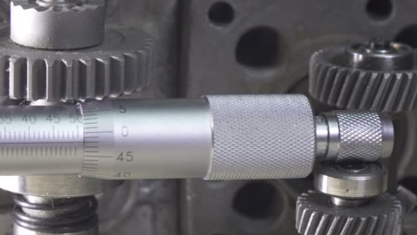 Industriellt stilleben en mikrometer mot bakgrund av detaljer av bilar och mekanismer. Dolly shot — Stockvideo