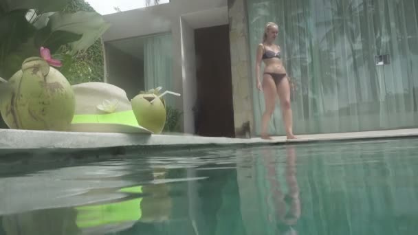 长头发的年轻苗条的妇女在水池休息和喝鸡尾酒从椰子在热带度假胜地 — 图库视频影像