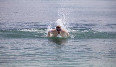 spor gözlük genç adam deniz kelebeği tarzında yüzer