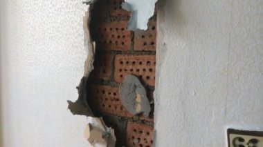 Dairede tamir. Kırmızı tuğladan kamp olmak üzere eski bir duvarın sökülmesi