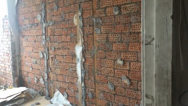 Repair in the apartment. Dismantling of an old wall covering under which to be a camp from a red brick — Stock Video