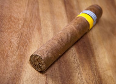 ahşap bir arka plan üzerinde bir tütün yaprağı haddelenmiş puro, keskinlik küçük derinliği