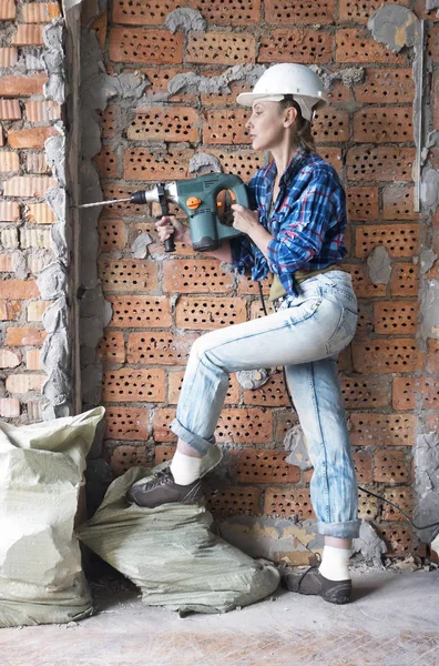 Kıyafetleri Koruyucu Bir Kask Genç Kadın Bir Tuğla Duvar Yanında — Stok fotoğraf