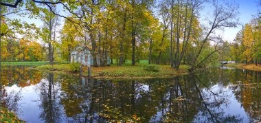 parlak yaprakları ile sonbahar parkı nehir tarafından eski mavi harap ev