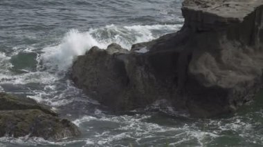 Güneşli bir günde, tropikal denizin kıyılarında, dalgalar kıyılarda siyah taşlarla ilerliyor, Yavaş Hareket